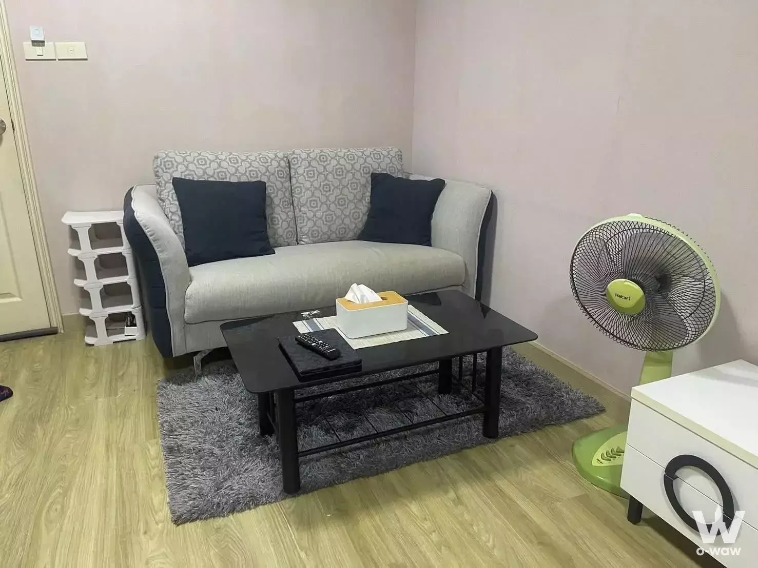 Compact living room corner in Lumpini Center Sukhumvit 77 condo with grey sofa and coffee table