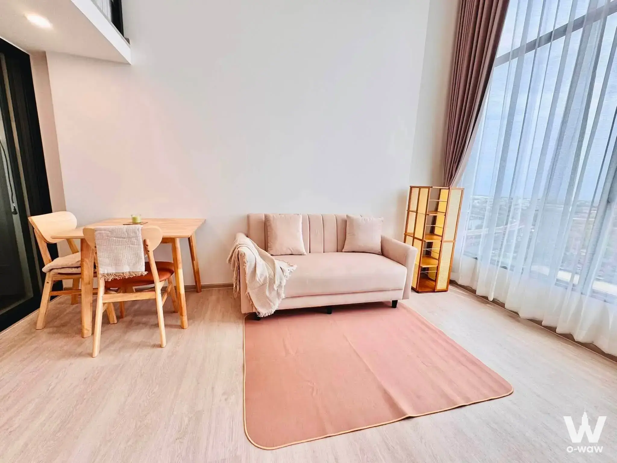 Beige sofa and oak dining set in this 1-bed condo for rent at Origin Plug & Play E22 Station with city views