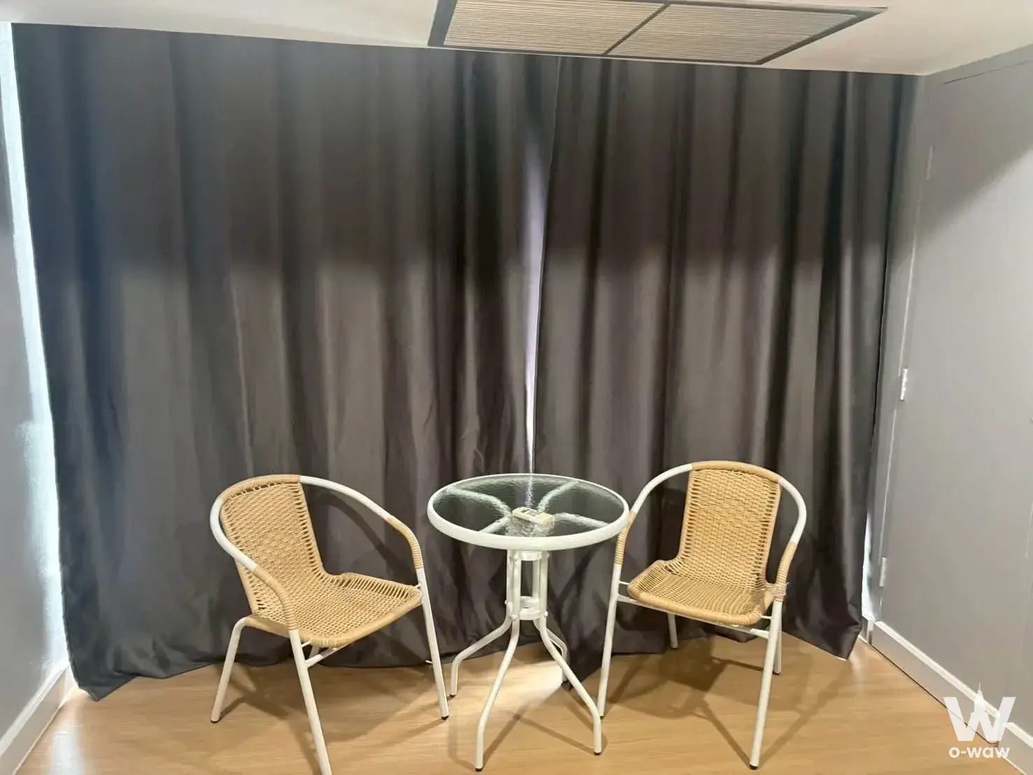 Enclosed balcony in Hyde Sukhumvit 13 rental with rattan bistro set and charcoal curtains