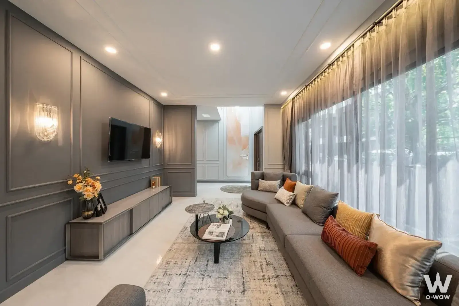 Spacious living area with a light-grey sectional sofa and glass coffee tables in this The City Sukhumvit-Onnut 2 home