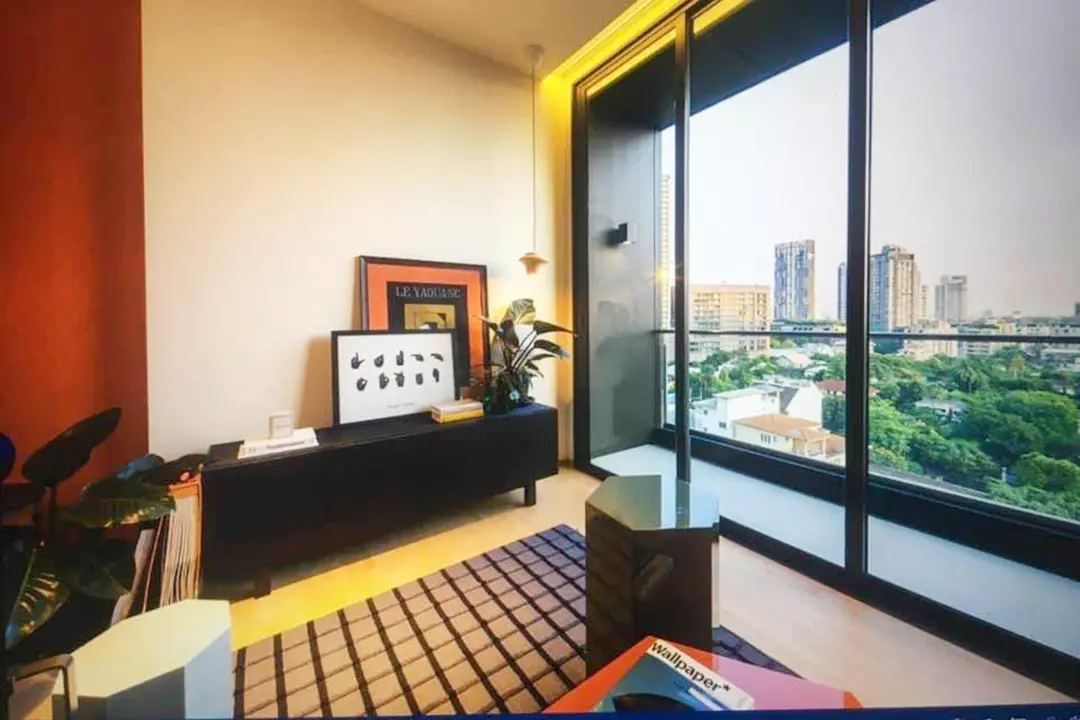 Modern BEATNIQ condo living room with burnt-orange feature wall, black media console, and balcony city views