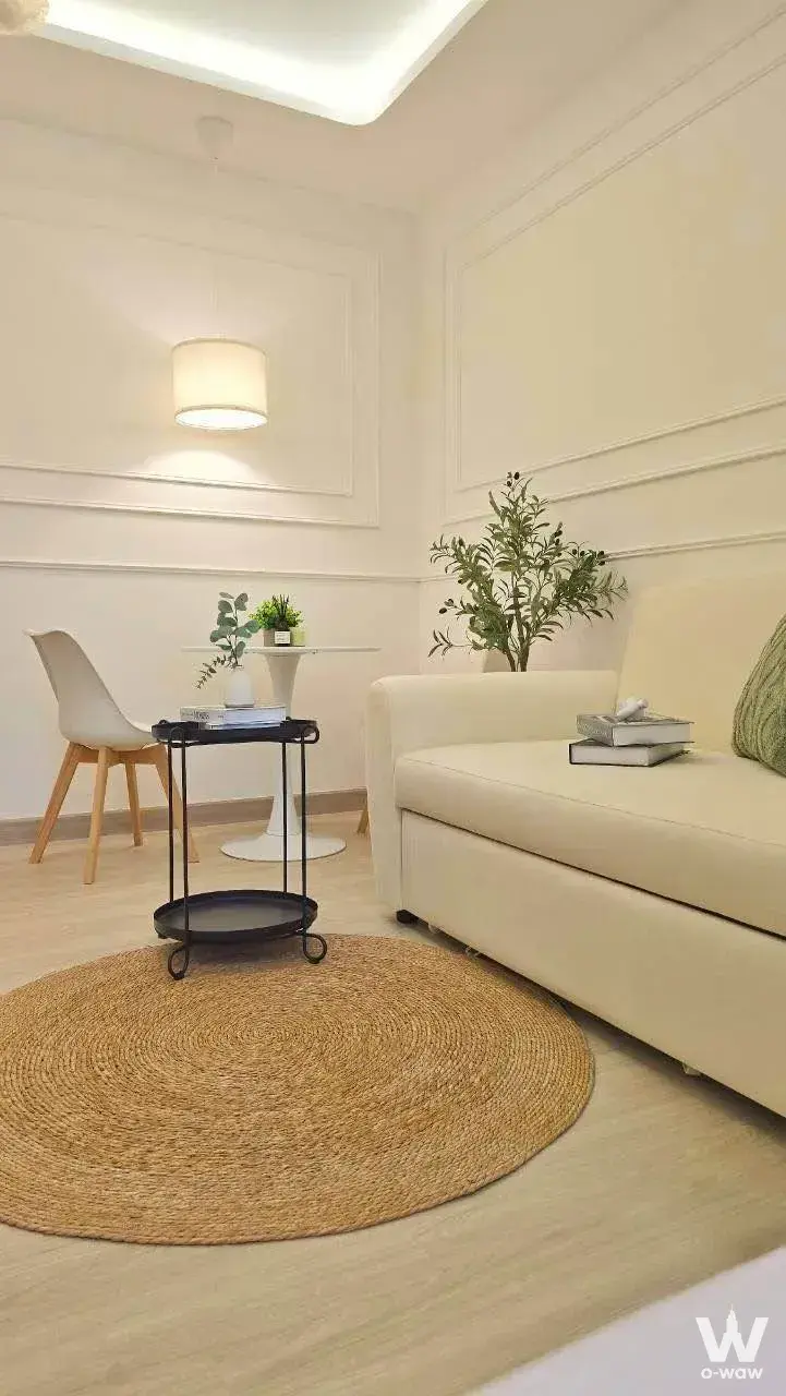 Lumpini Center Lat Phrao 111 living room for sale has a cream sofa and jute rug