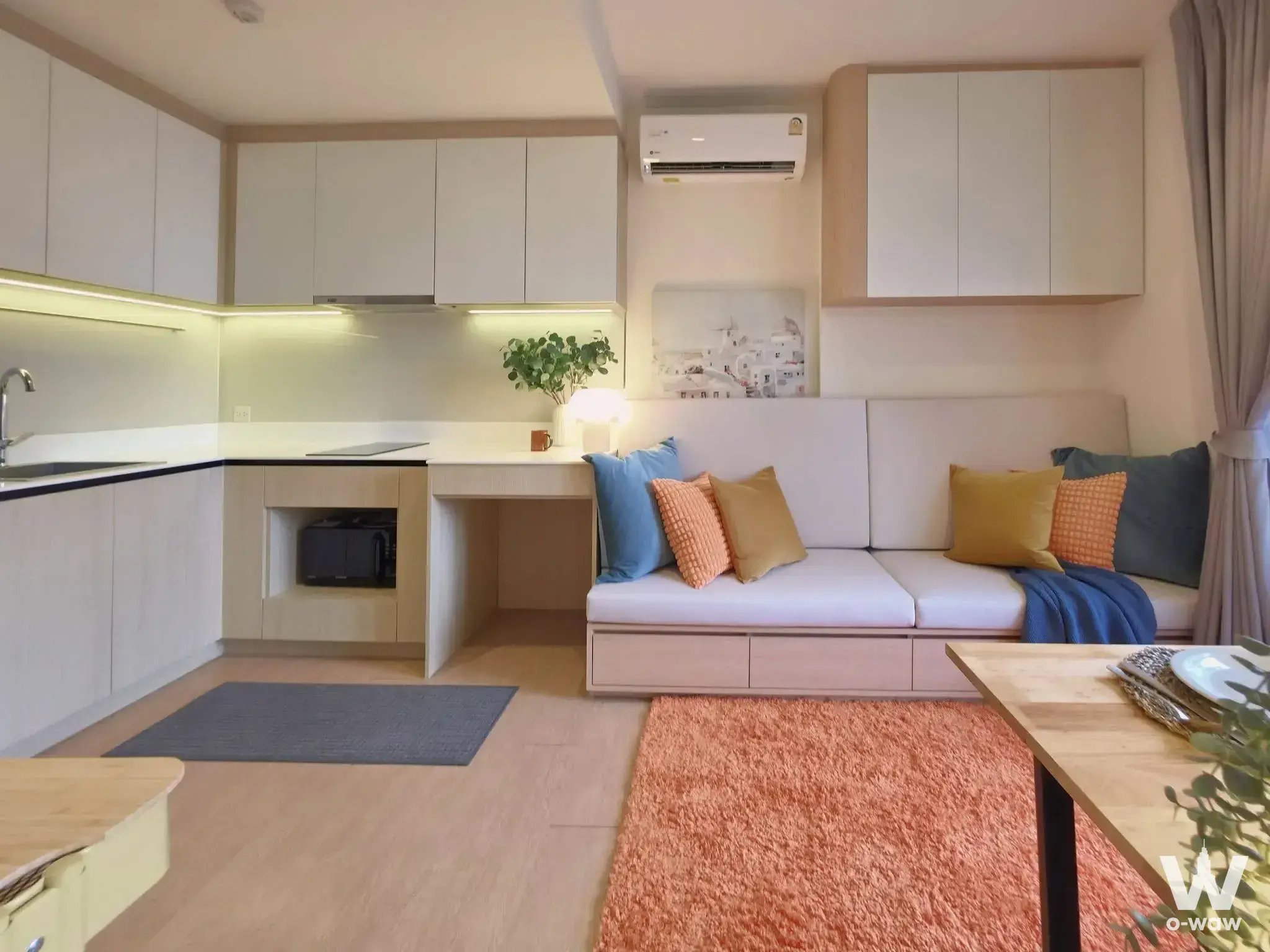 MARU Ekkamai 2 studio featuring wood-look floors, white kitchen, and colorful throw pillows