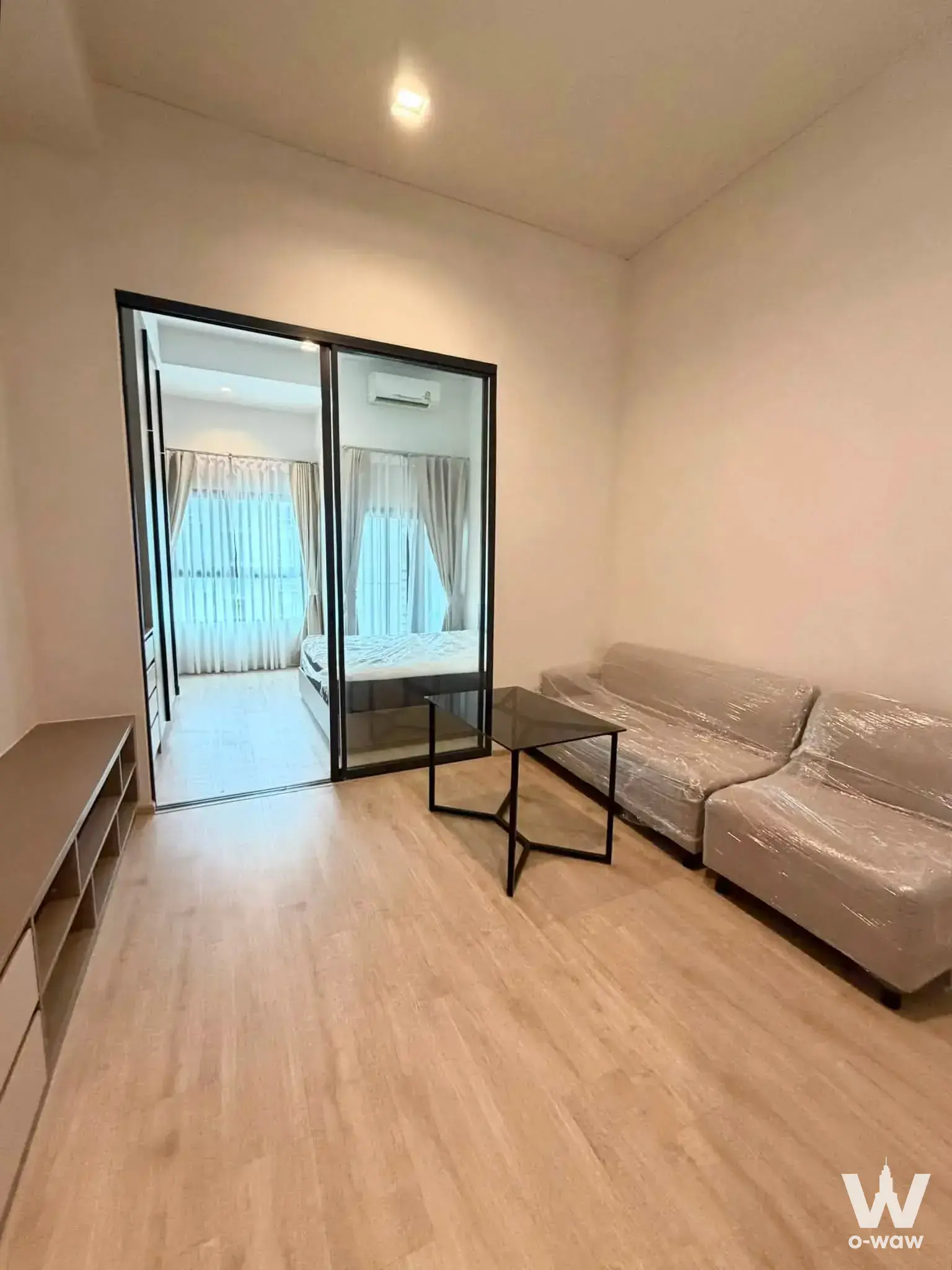 Studio living area with glass partition to bedroom in Ideo Sathon-Wongwian Yai rental