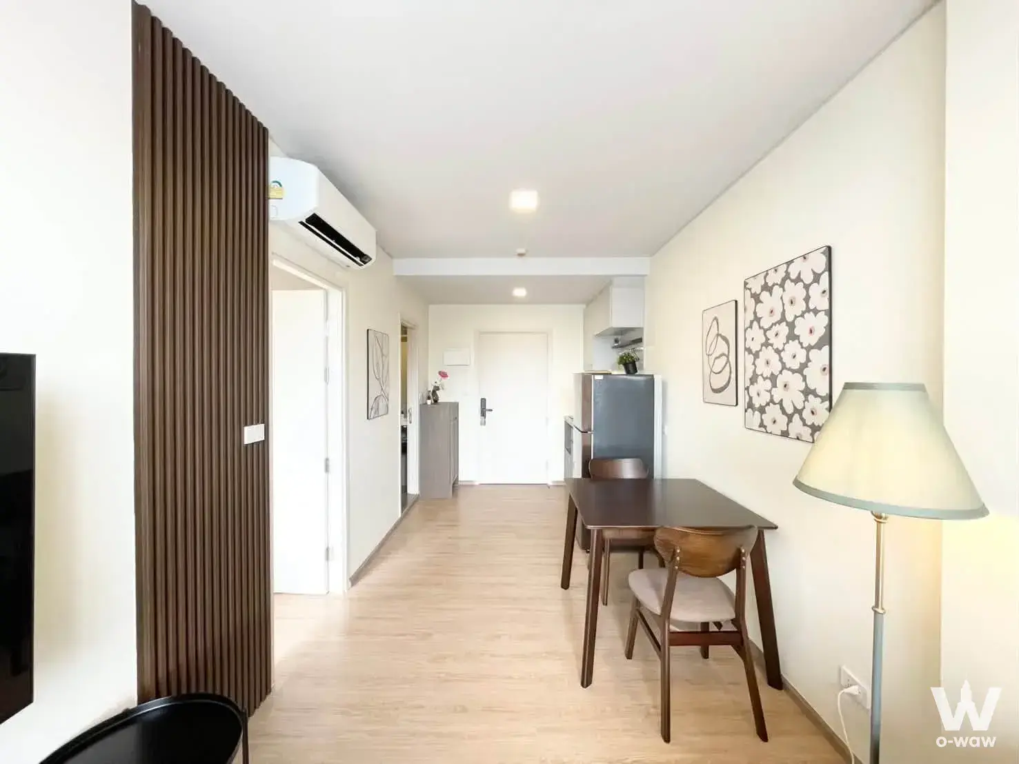 Open-plan studio with dark wood slat partition and dining set in this 1-bed condo for rent at QUINTARA MHy'ZEN PHROM PHONG