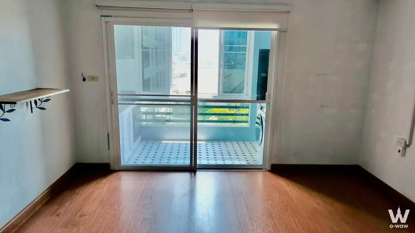 Empty 1-bed condo unit in Rama 6 Mansion B with wood-look floors and balcony access