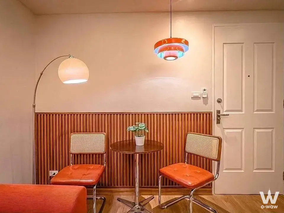 Cozy vintage-modern dining nook in Happy Condo Rachada 18 with cane chairs and retro pendant lighting
