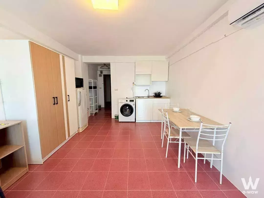 Compact 1-bed Rimhad Condo living area with built-in wardrobe, dining set, and open kitchenette