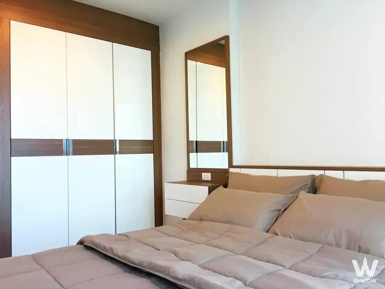 Fully furnished bedroom with white wardrobe and walnut accents in RHYTHM Sathorn, a 1-bed condo for sale