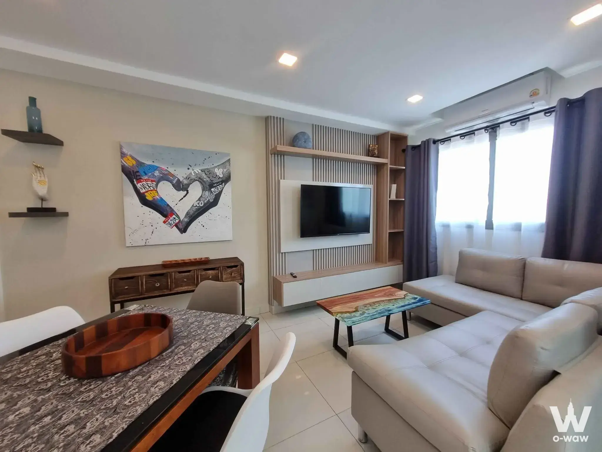 Furnished living area in Laguna Beach Resort 2 condo with beige sofa and wooden accent wall