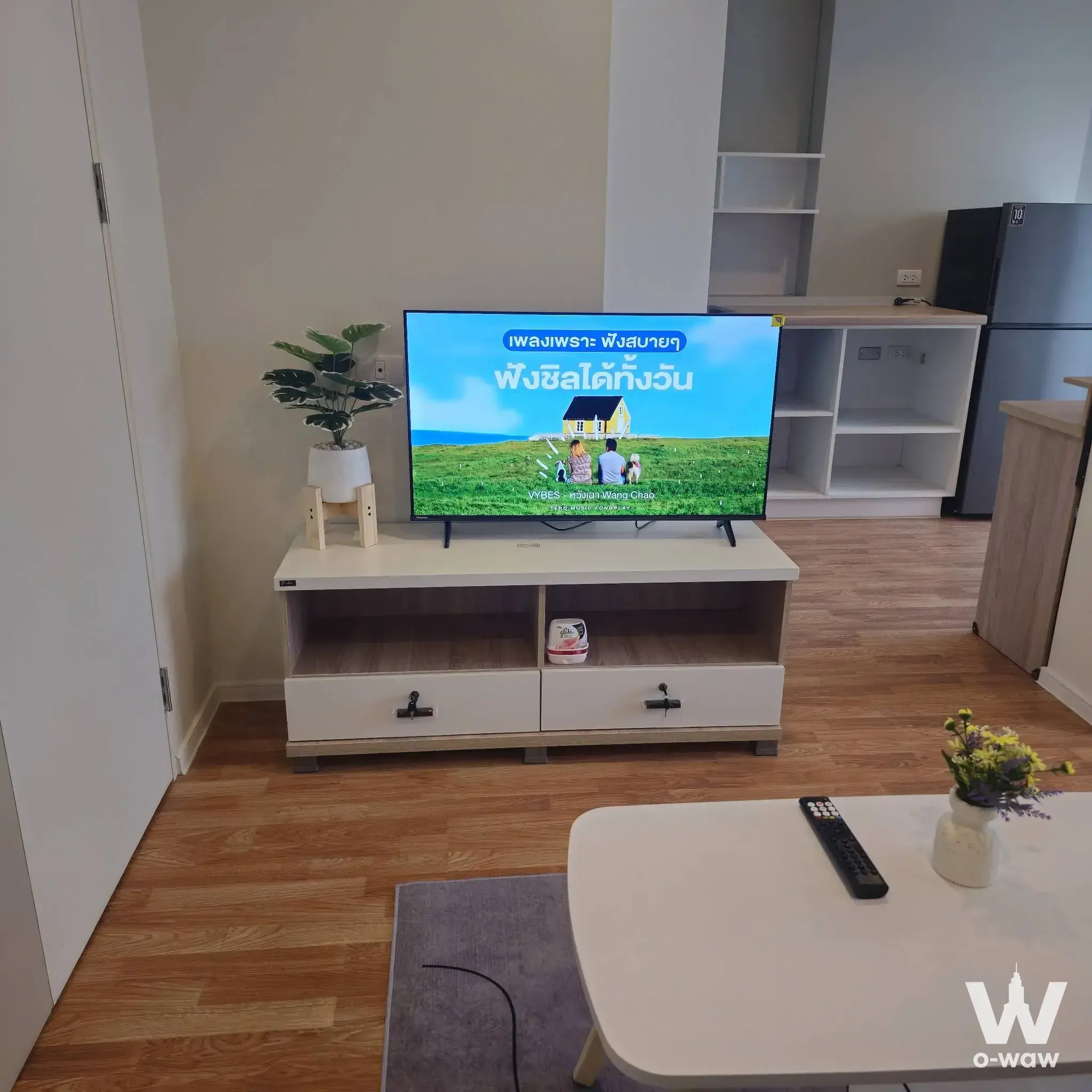 Living room in a Lumpini Park Phetkasem 98 condo showing flat-screen TV on white console and light wood flooring