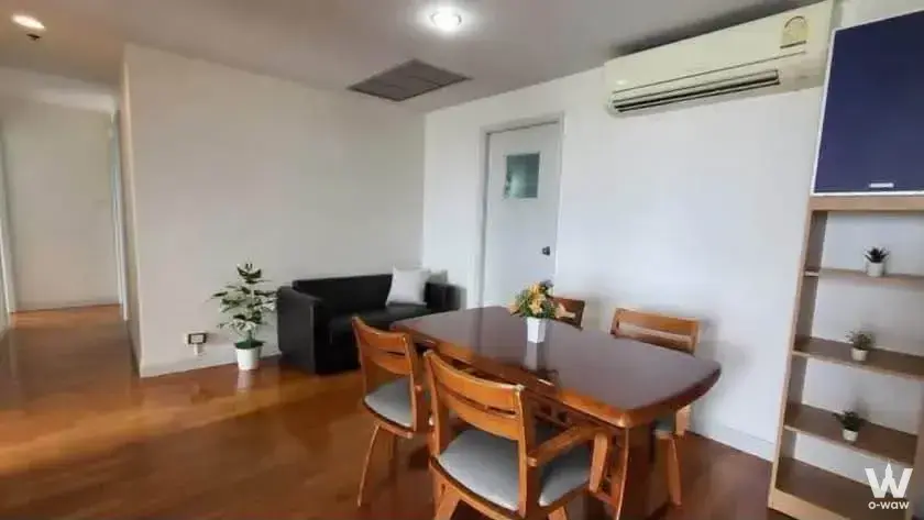 3-bed condo for rent in Lumpini Place Water Cliff living room with honey-brown wood floors and dining set