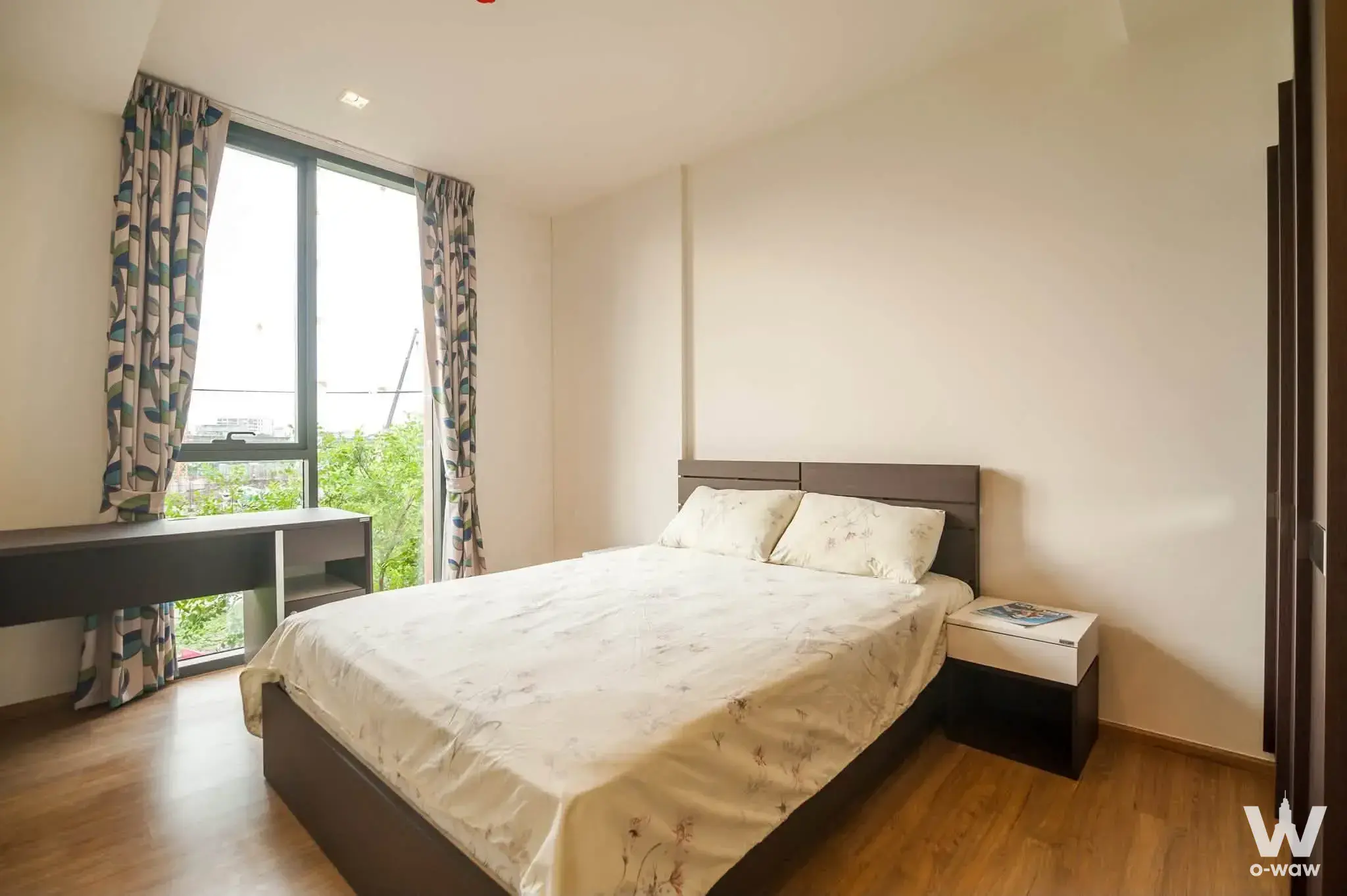 Modern bedroom in HASU HAUS with dark wood bed frame and leaf-patterned curtains