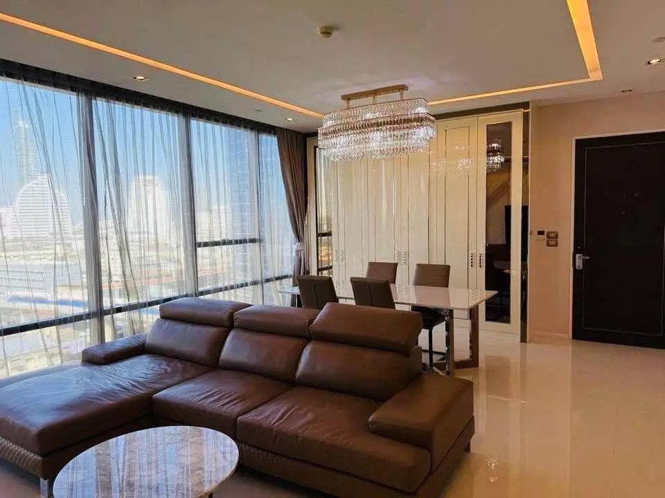 Spacious living room in The Bangkok Sathorn 2-bed condo featuring leather sofa and skyline views