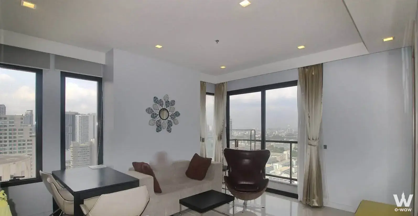Modern living area with egg chair and skyline view in 2-bed M Phayathai condo