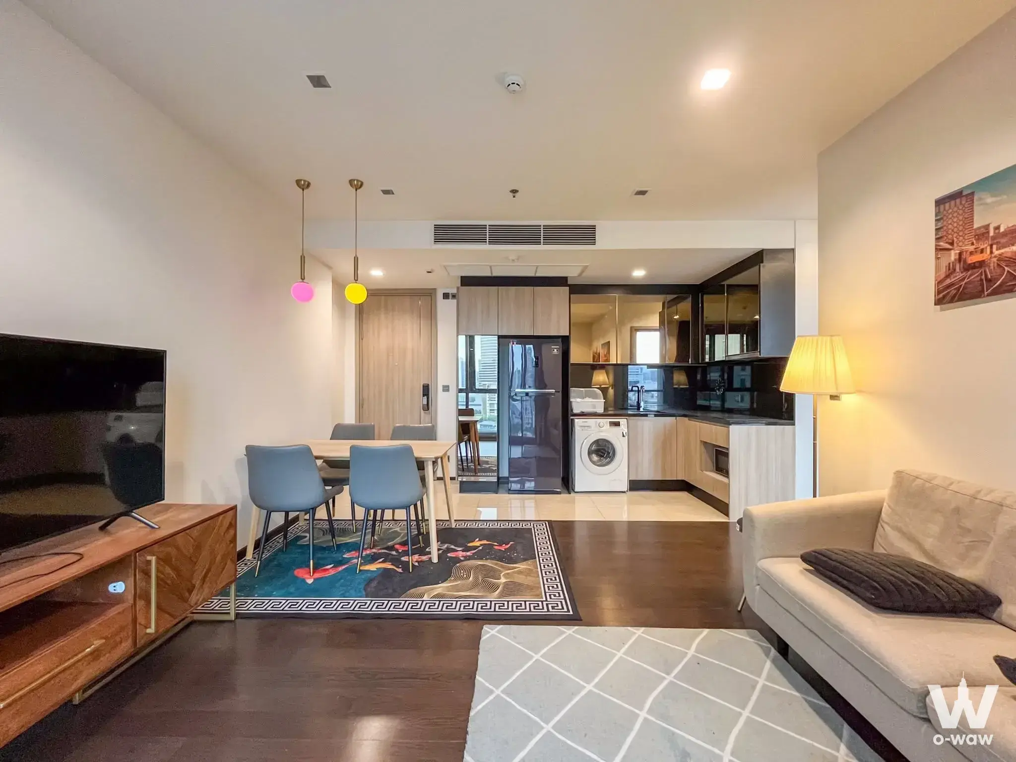 2-bed condo for rent in THE LINE Ratchathewi with dark wood floors, colorful pendant lights, and fully furnished kitchen