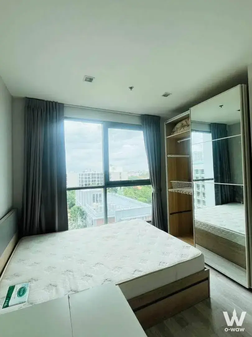 Bedroom with city view and mirrored wardrobe in Ideo Mobi Sukhumvit 81 1-bed rental unit