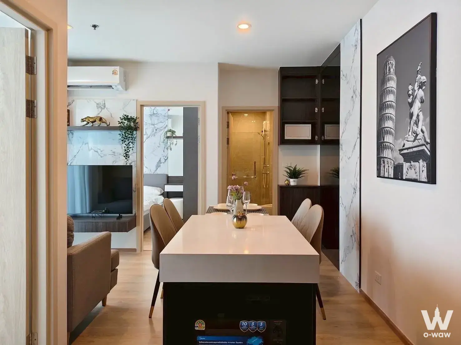 Open-plan living area with marble accents and dining set in 2-bed Nue condo
