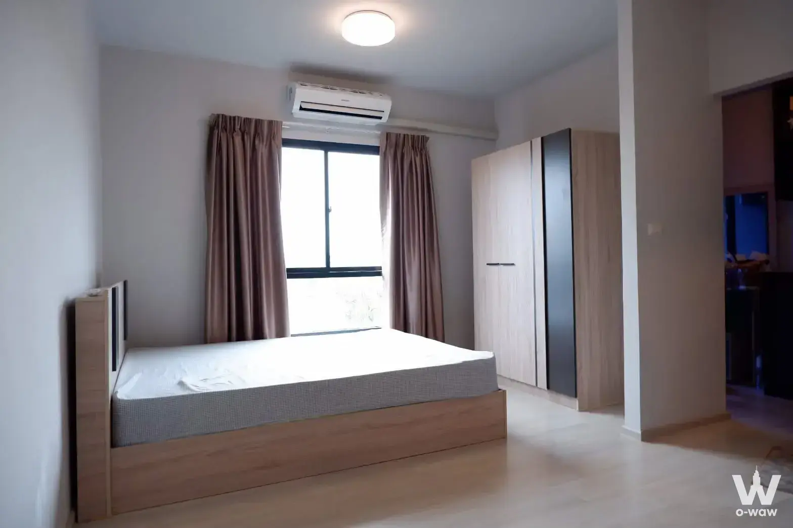 Unio Ramkhamhaeng bedroom featuring light wood bed frame and built-in wardrobe
