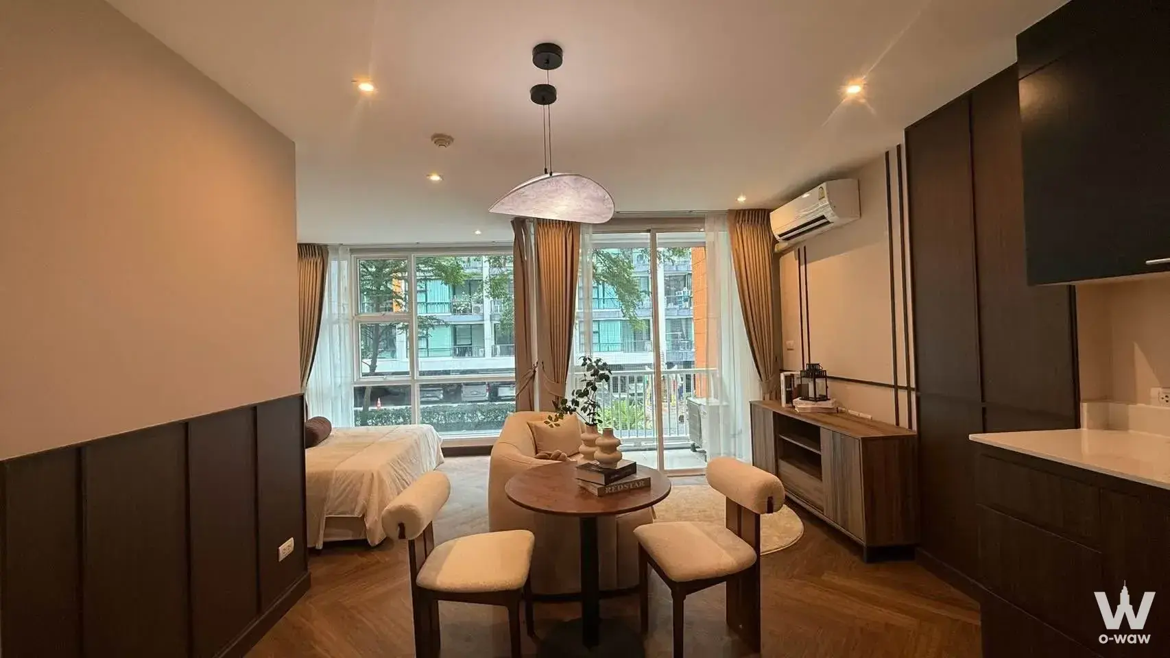 Open-plan studio with dining nook and balcony access in D65 Condominium, a 1-bed condo for sale in Bangkok