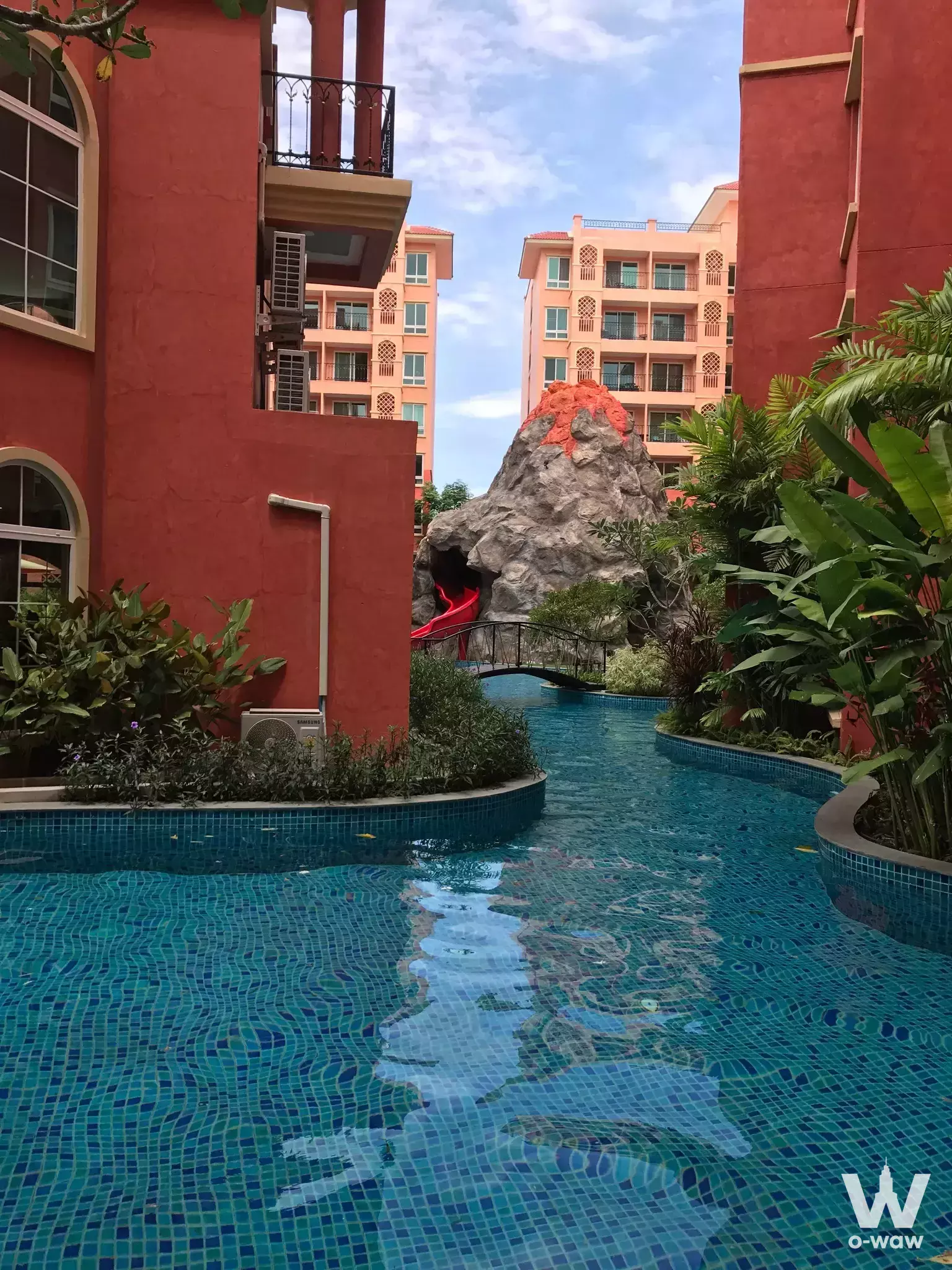 2-bed condo for sale in Seven Seas Condo Resort Jomtien featuring a tropical pool with rock formation and red slide