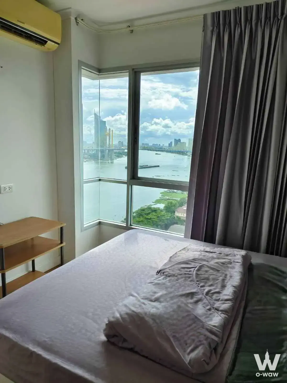 Queen bed facing bay window with river view in this Lumpini Park Riverside Rama 3 one-bed condo