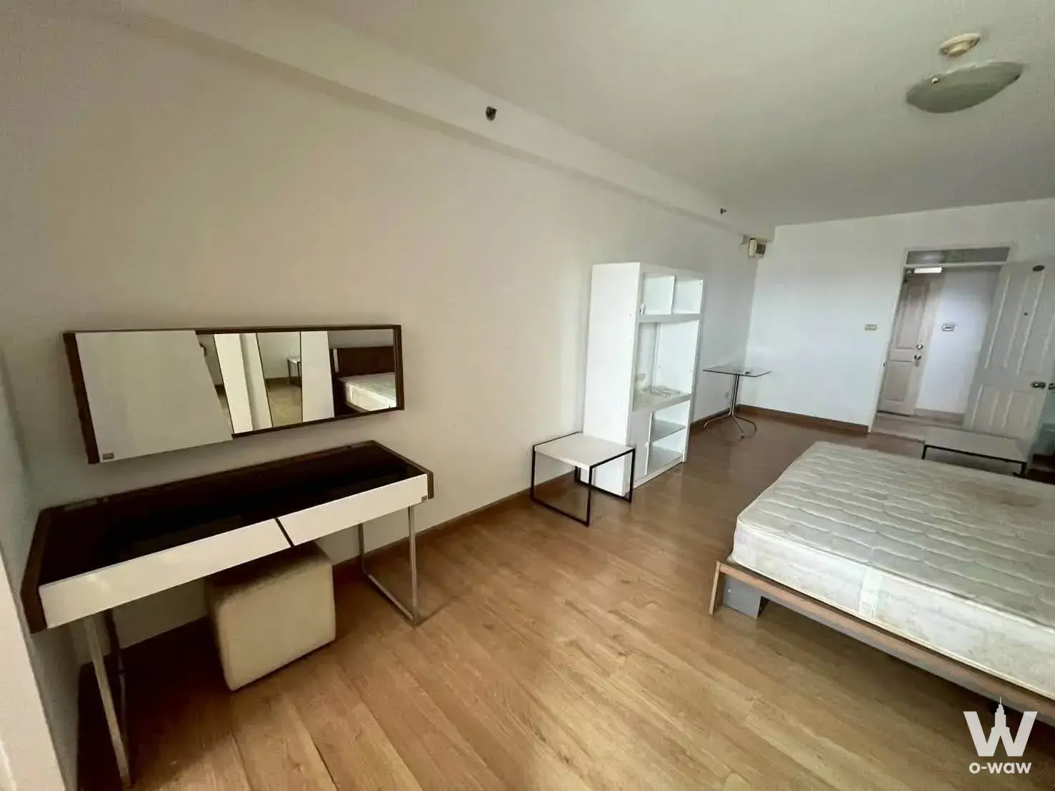 Master bedroom with light wood floors and a vanity desk in a Supalai Park Srinakarin condo for sale