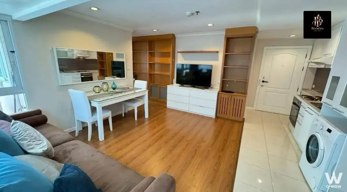 Open-plan living area in 2-bed Grand Park View Asoke condo with sectional sofa and compact kitchen