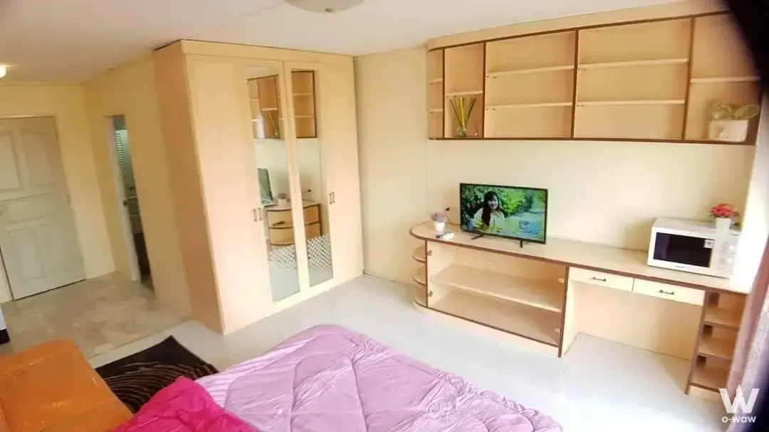 Family Park 2-bed condo bedroom featuring mirrored wardrobe, purple quilt, and desk