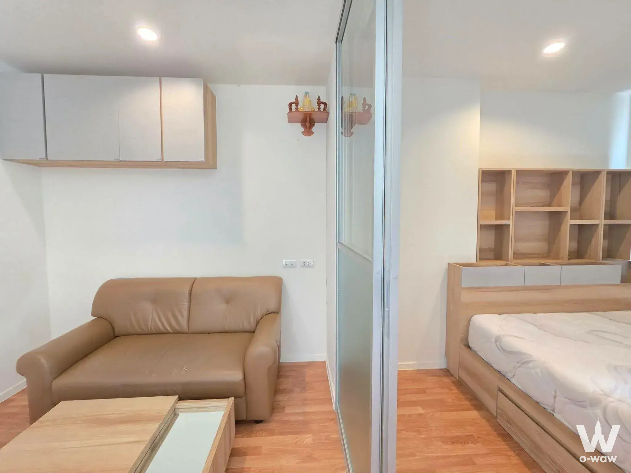 Studio apartment with frosted glass partition separating living area from platform bed in Lumpini Park Phetkasem 98