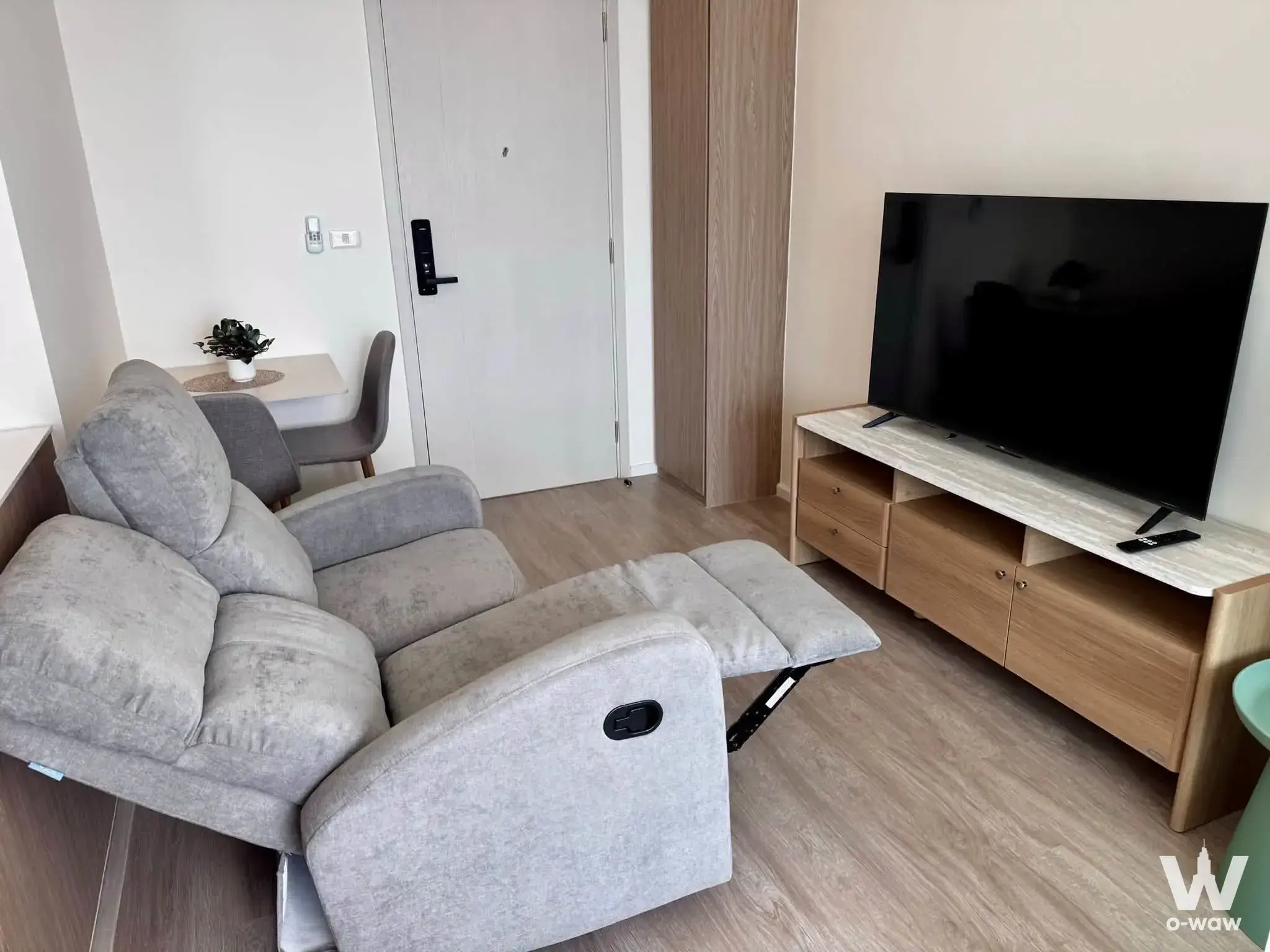 Living room in De Lapis Charan 81 condo with recliner sofa, media console, and dining nook