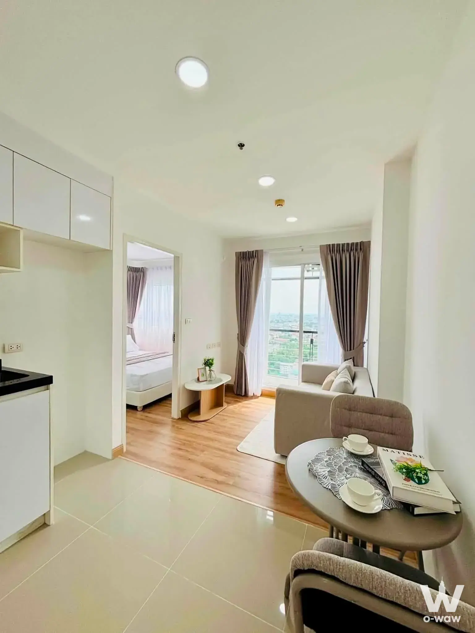Modern 1-bed condo for sale in Bangkok Horizon Ratchada-Thapra with open-plan living, wood-look floors, and balcony city