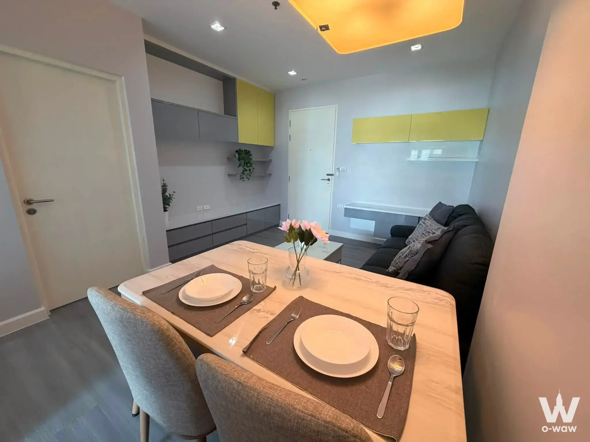 Dining area in The Room Ratchada-Ladprao condo featuring marble table and yellow cabinets