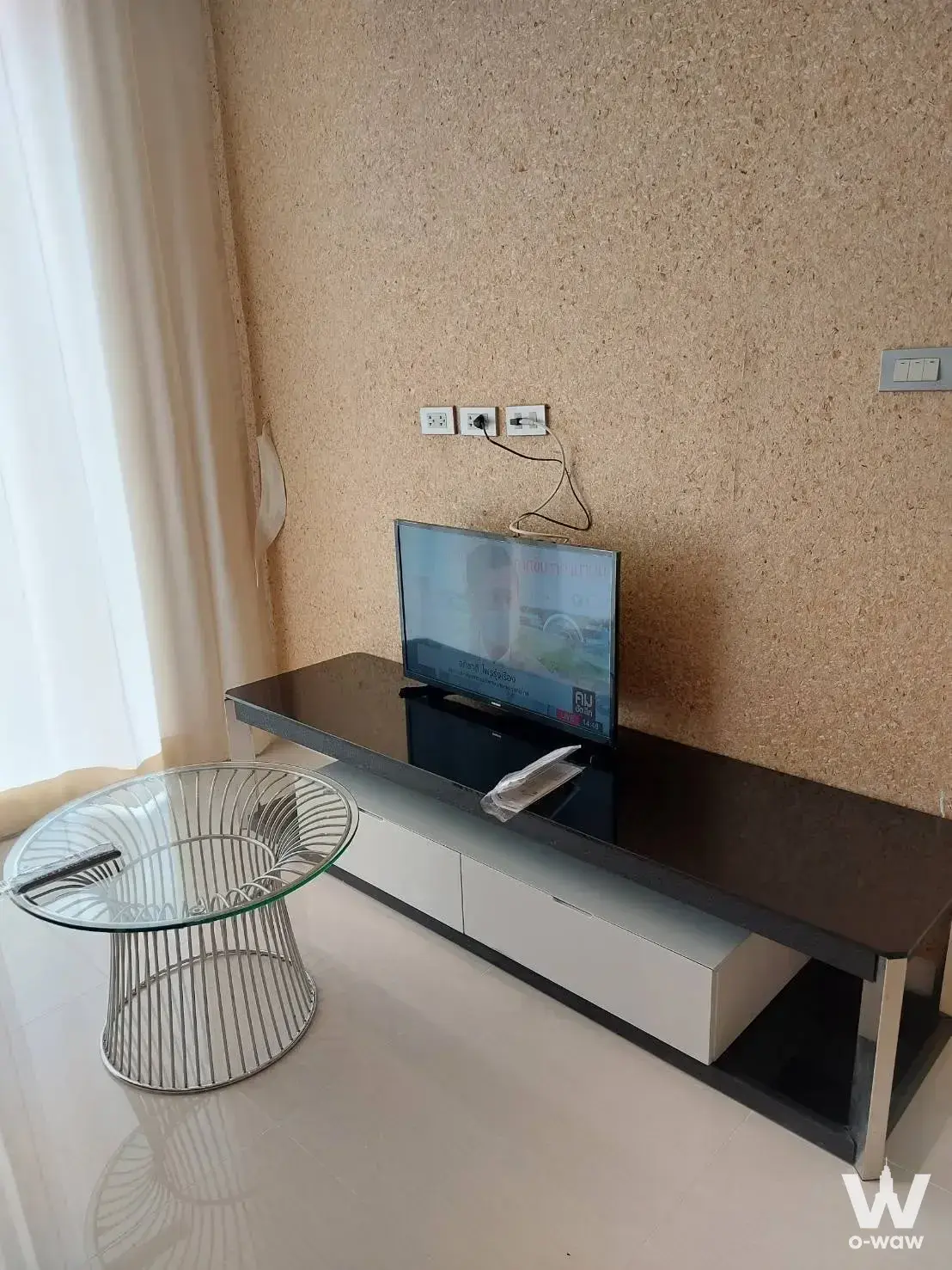 Minimalist living area in a Grande Caribbean Condo rental with media console and glass coffee table