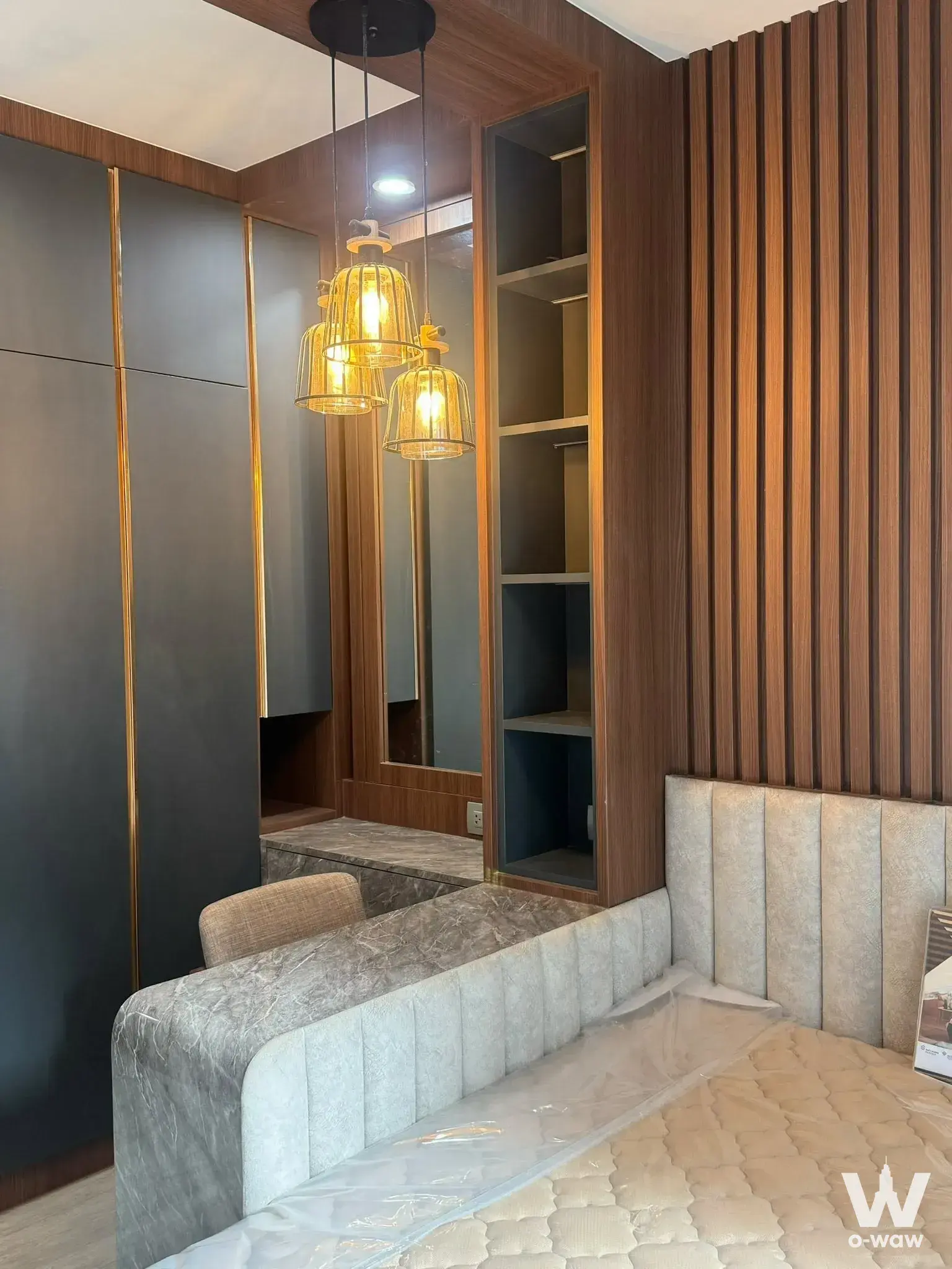 Bedroom with beige bed, charcoal wardrobe, and gold-trimmed vanity in Life Asoke Rama 9 1-bed condo for rent