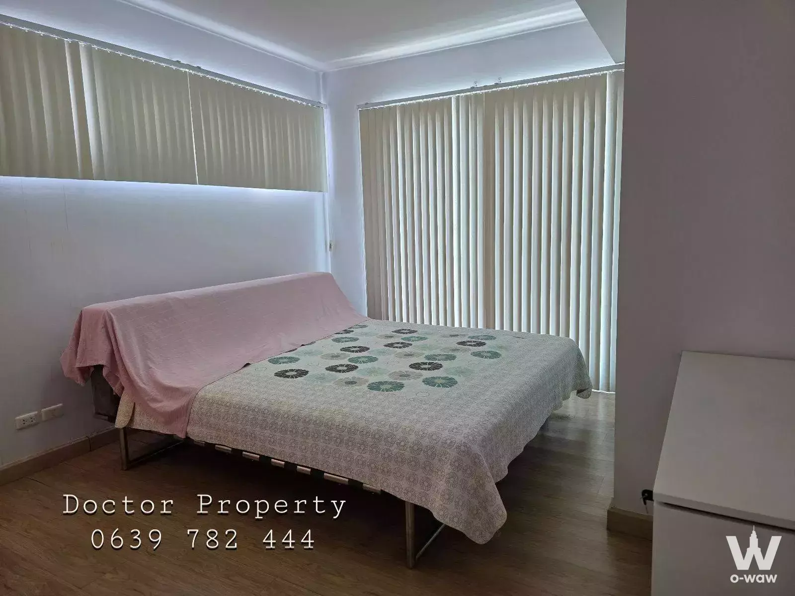 Sparsely furnished bedroom in Supalai Casa Riva condo with sofa bed and floor-to-ceiling windows