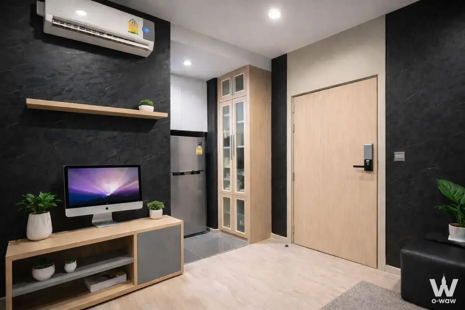 Modern living room with charcoal walls, oak furniture, and iMac in a 1-bed condo for sale in M Thonglor 10