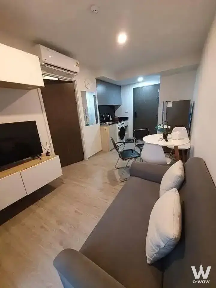 1-bed condo for sale in DOLCE LA SALLE featuring modern minimalist studio with grey sofa and floating media console