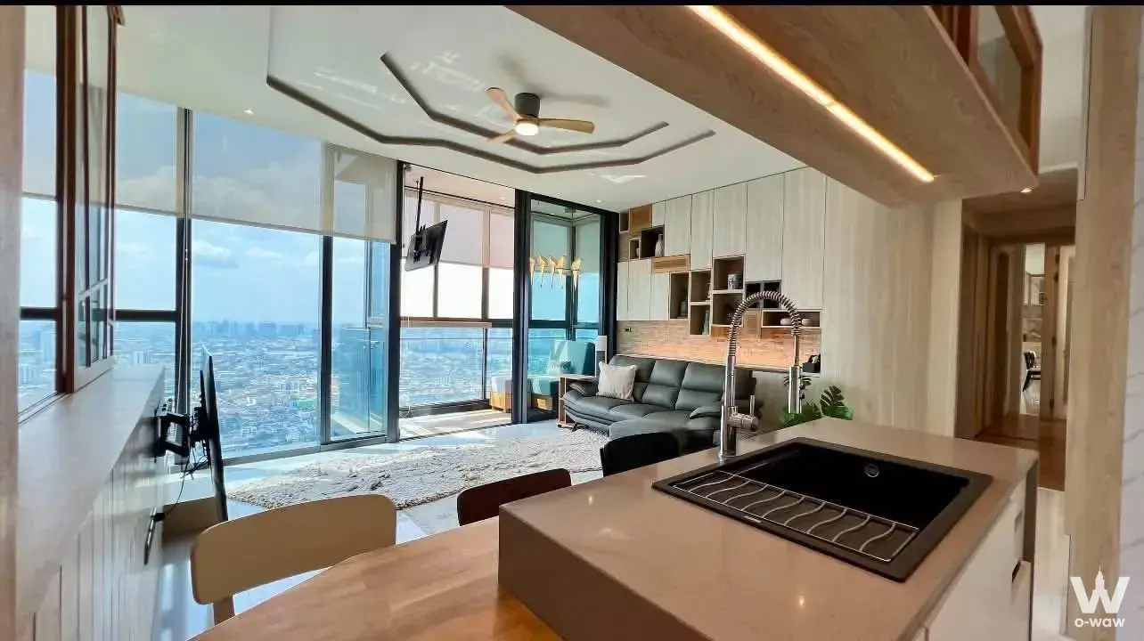 Canapaya Residences 2-bed condo with grey leather sofa and panoramic city skyline view