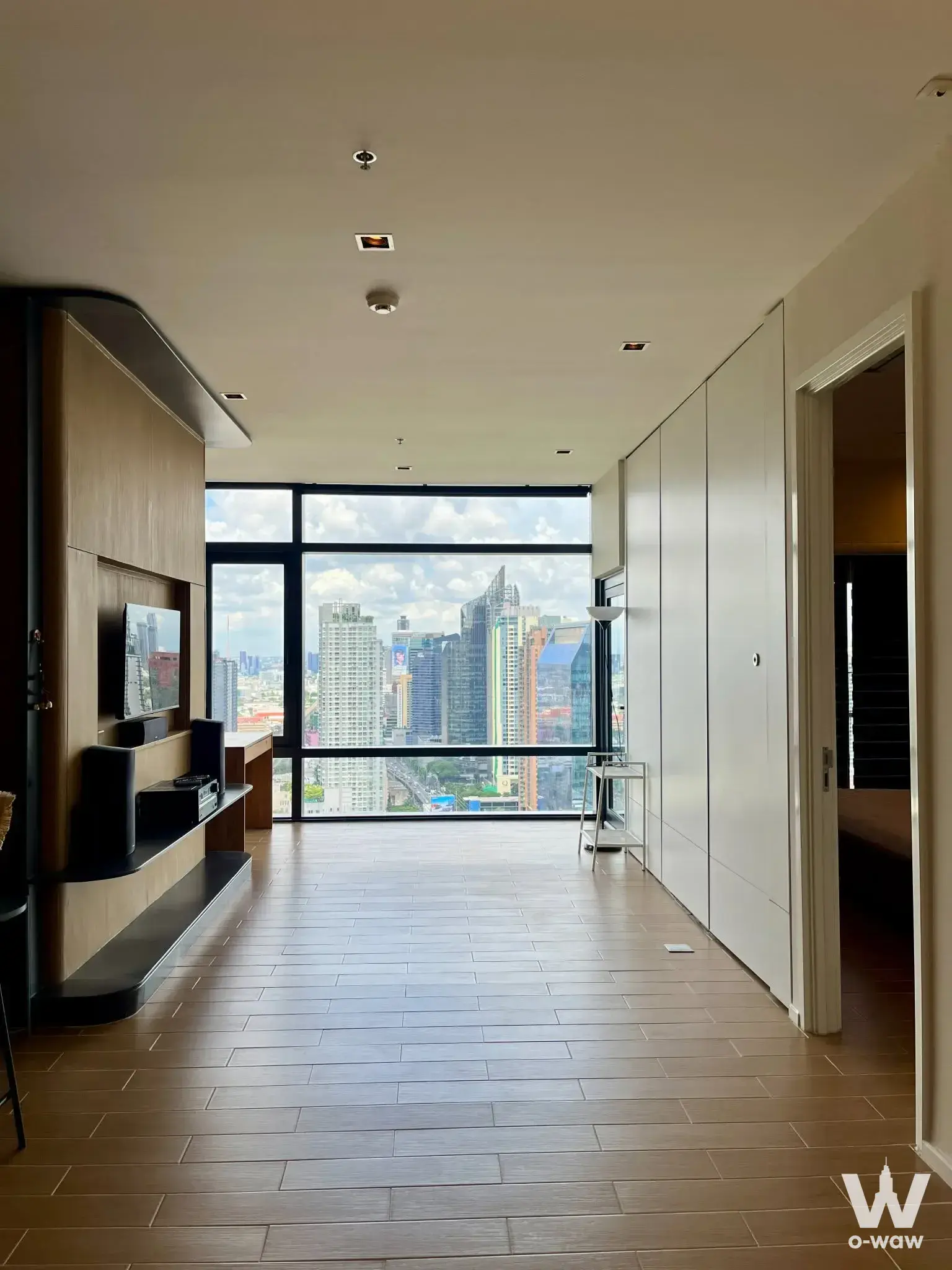 Living room in Circle Living Prototype 1-bed condo with city view windows and built-in media unit