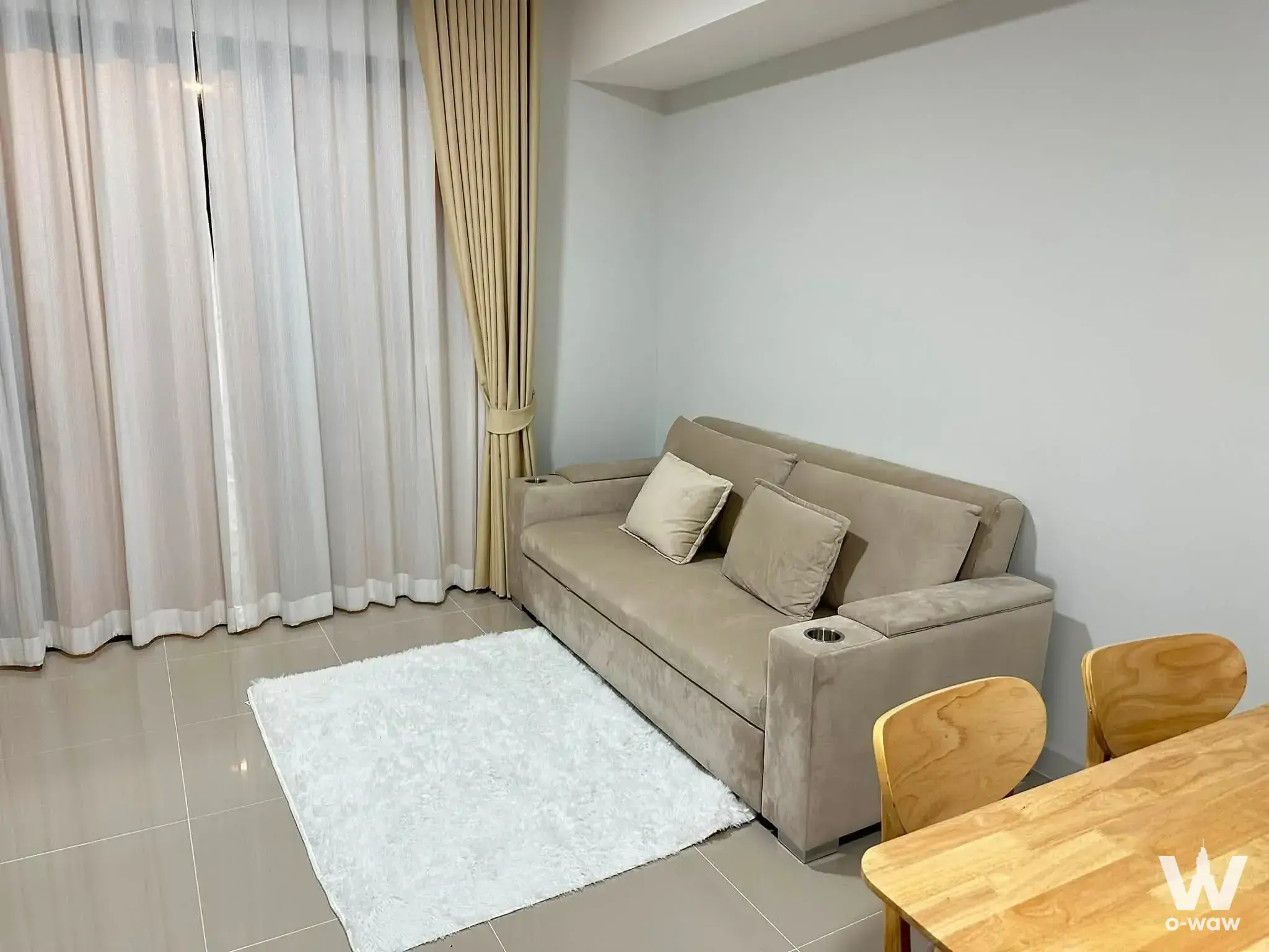 Beige sofa on white rug in open-plan living area of 3-bed house for rent at Pleno Sukhumvit-Bangna 2