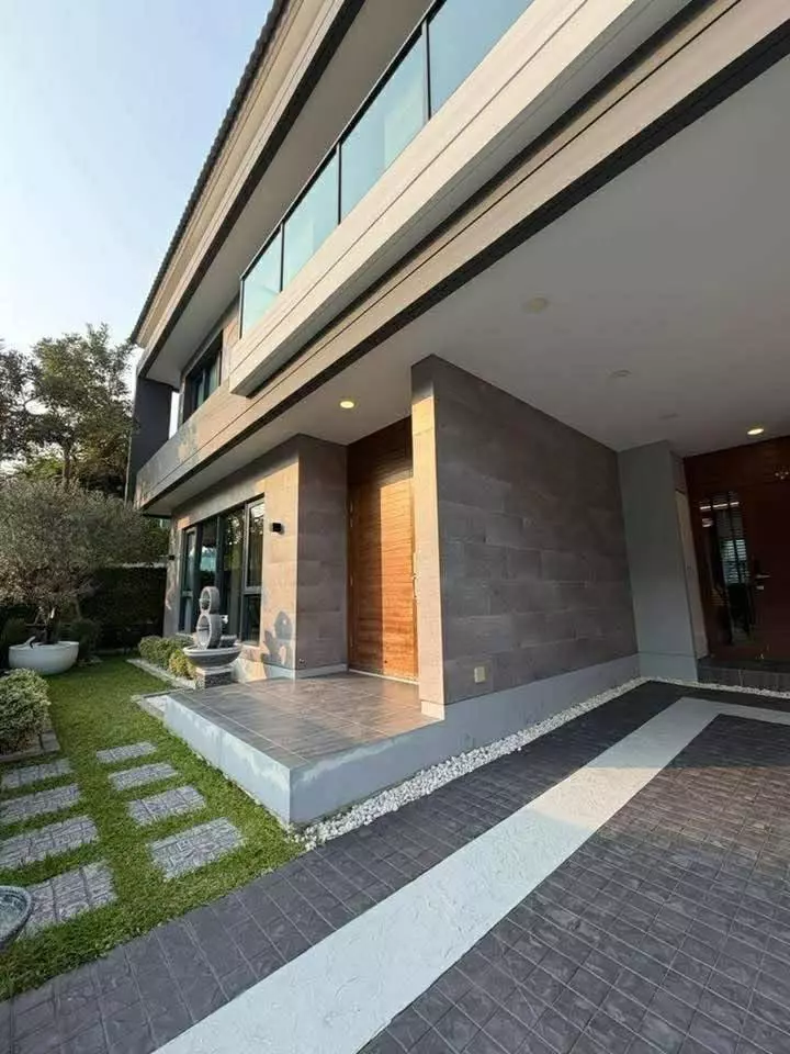 Exterior of modern two-story house for sale in The City Bangna with stone columns and manicured lawn