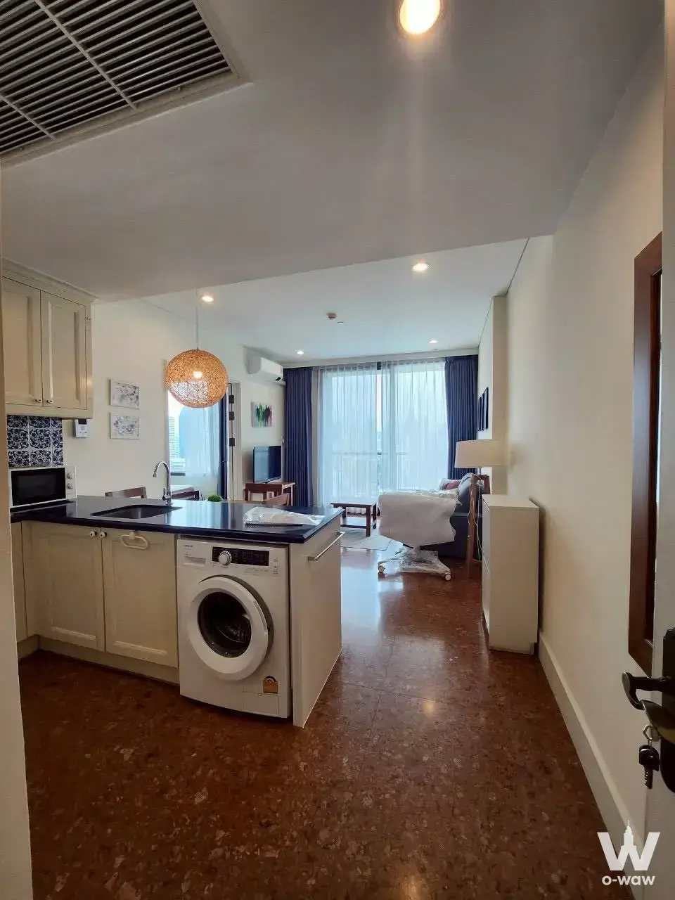 Cream cabinets and granite island in the kitchen of this Aguston Sukhumvit 22 condo for sale
