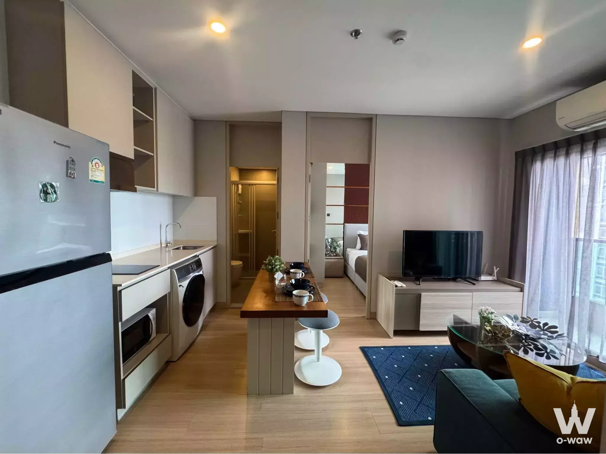 2-bed condo for rent in Lumpini Suite Phetchaburi with teal sofa and kitchen