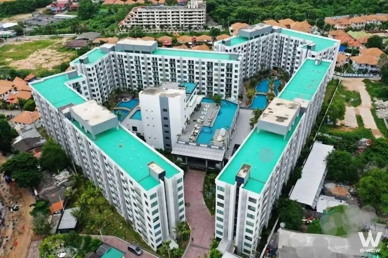 Aerial view of Arcadia Beach Resort Condominium highlighting U-shaped layout, teal rooftops, and central pools