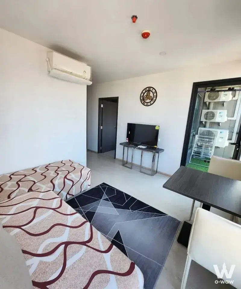 Living area featuring beige sectional sofa and dining set in this furnished 1-bed condo for rent at ELIO DEL NEST