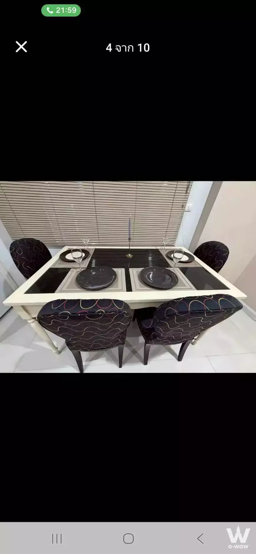 Perfect Place 2 condo dining area with glass-top table, patterned chairs, set for four, and glossy white tile floors