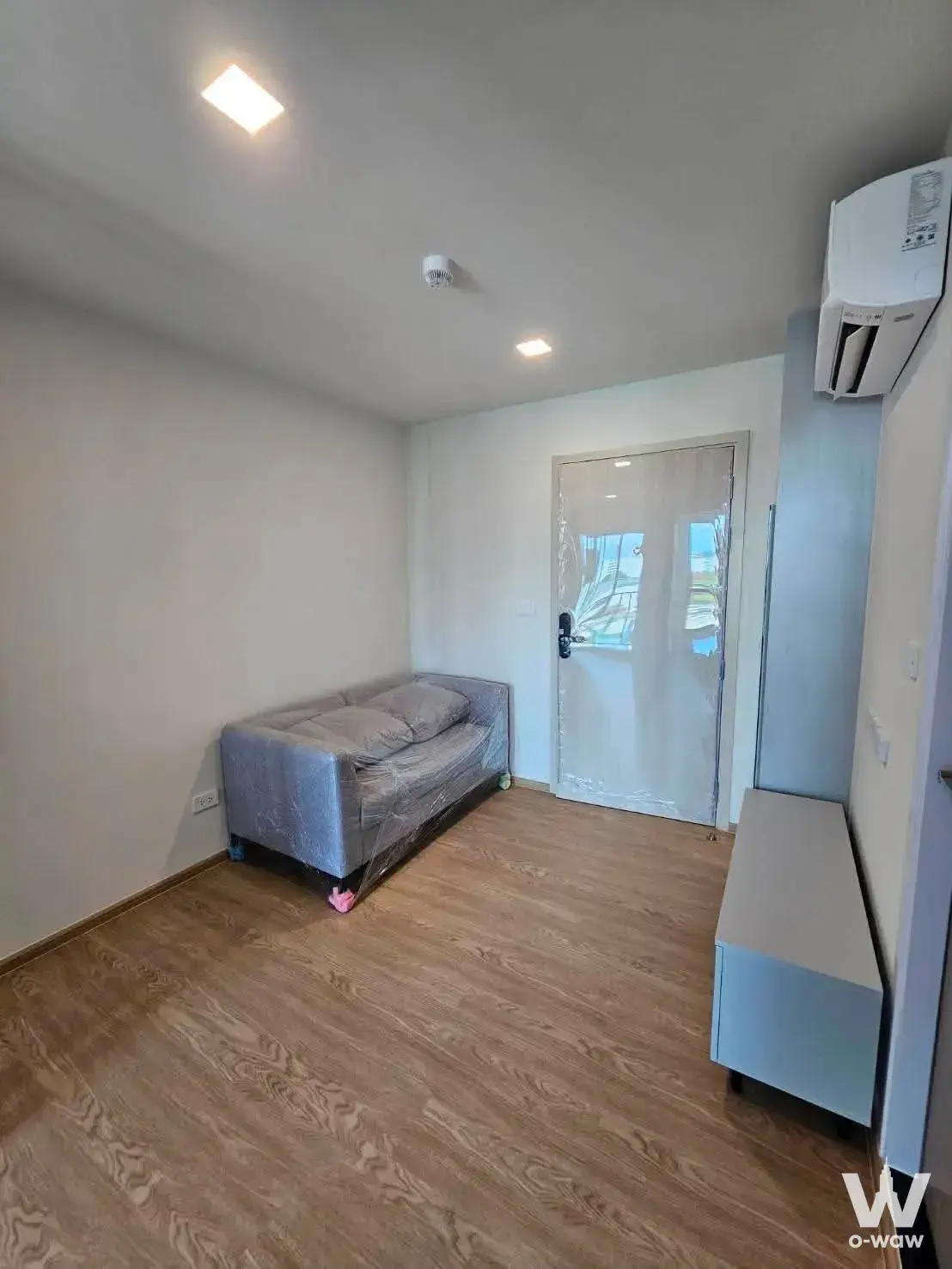 1-bed condo for rent in Kave Luminous Bangmod with light-brown laminate floors and a grey sofa