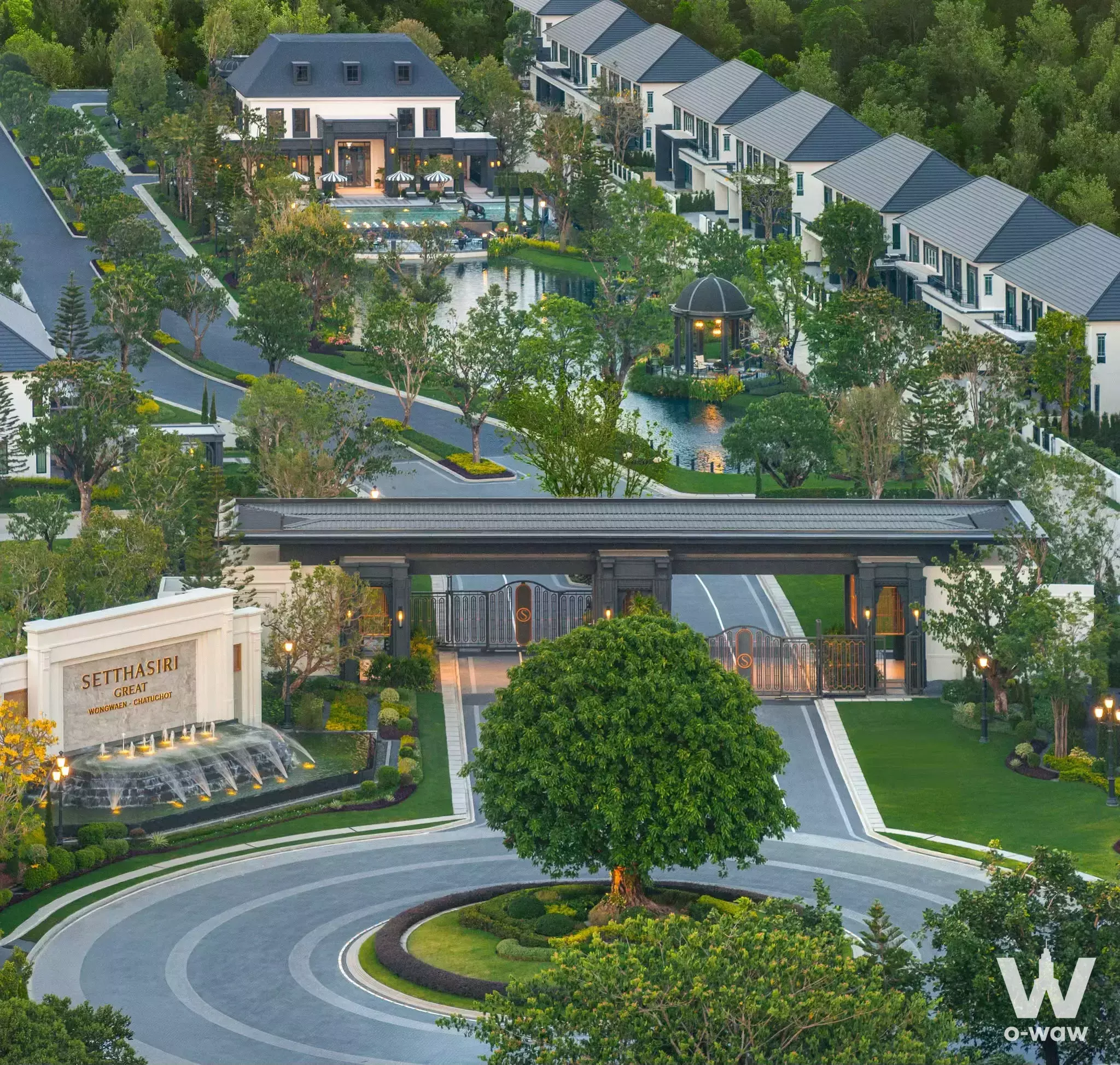 Grand entrance of Setthasiri Wongwaen-Chatuchot featuring traditional gatehouse, water fountain, and lush landscaping for