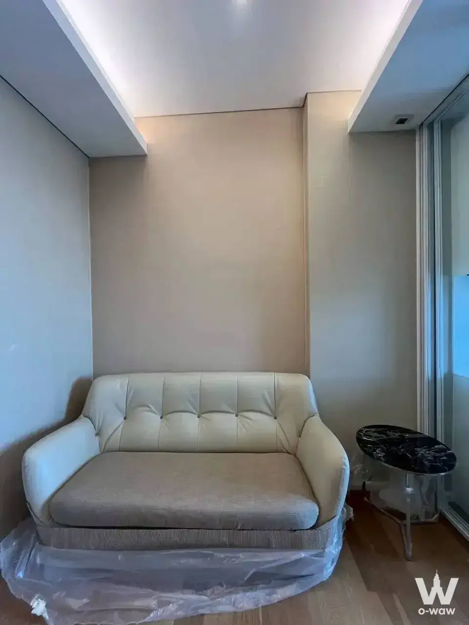 The Saint Residences 1-bed rental living corner with tufted leather sofa and marble side table